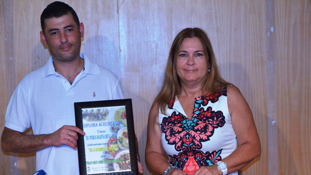 La Concejala de Turismo y Festejos, Isabel López, le hace entrega del galardón al premiado