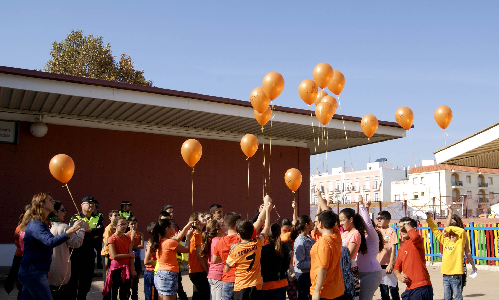 Los escolares ha realizado una suelta de globos naranjas